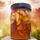 Jar of Honey-Fermented Garlic with summery grasses and sunlight in background